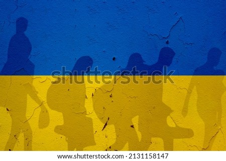 Ukraine flag on wall and refugee shadows. Ukraine war concept. Royalty-Free Stock Photo #2131158147