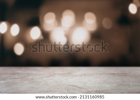 Brown marble bar counter top with empty space for text or digital product mockup. Blurred lights in the background. Royalty-Free Stock Photo #2131160985