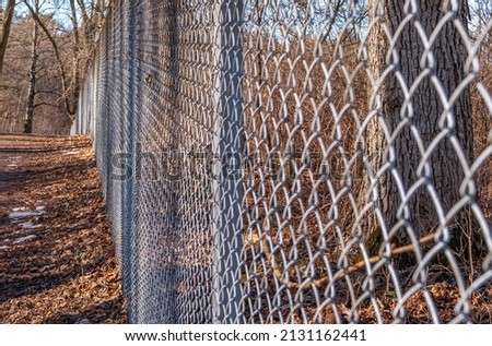 A closeup shot of a woven metal fence in a park