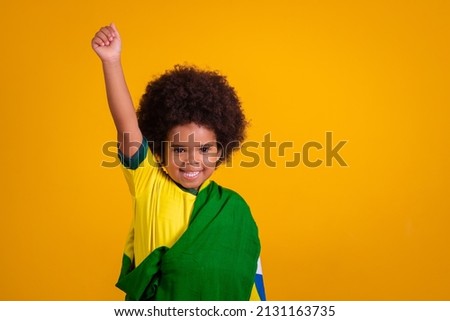 child girl latin american cheering for brazil at world cup 2022 patriot nationalist waving brazil flag cheering and jumping, symbol of happiness, joy and celebration, with flag of brazil Royalty-Free Stock Photo #2131163735