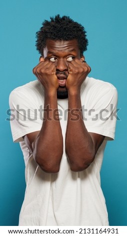 Portrait of frightened man having hands on mouth. Scared person feeling anxious and panicked in studio while looking at horror scene and scary movie. Afraid adult having terrified reaction Royalty-Free Stock Photo #2131164931