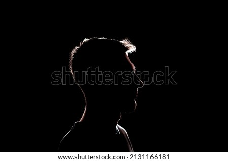 dark backlight shadow silhouette of male person, incognito unknown profile Royalty-Free Stock Photo #2131166181