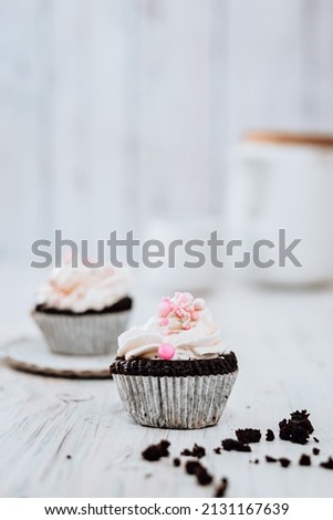 Still life photography of Cupcake with pink pearl decoration on rustic wooden tray on white background, selective focus, blur background.