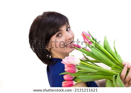 A 40-year-old brunette with a bouquet of bright spring tulips on a white background.