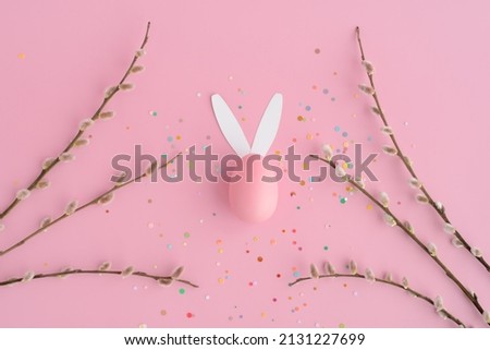 Easter bunny egg, confetti, pussy willow on a pink background.  Easter banner with space for text
