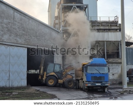 Blue truck loading in concrete and cement factory. Heavy industry manufacturing pile floor and building. Industry stock photo