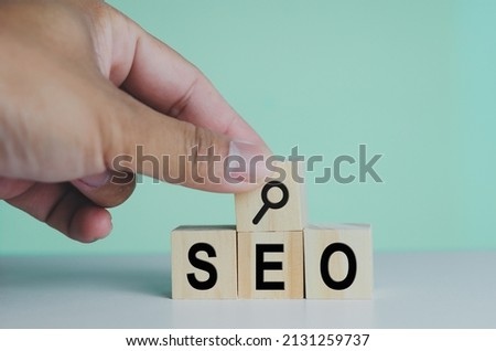 wooden cubes for SEO Search engine optimization magnifying glass icon on background.Copy space.