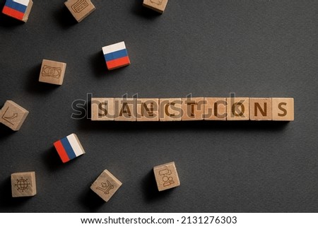 Wooden cubes with financial icons, Russian flag and sanctions. Concept on sanctions in Russia Royalty-Free Stock Photo #2131276303
