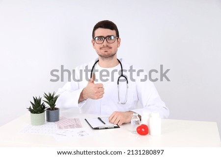 Doctor intern sitting at workplace on white background
