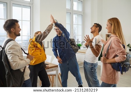 Smiling young multiracial people give high five celebrate shared success. Happy teen students enjoy good test result or high grade. College or university education achievement or accomplishment. Royalty-Free Stock Photo #2131283219