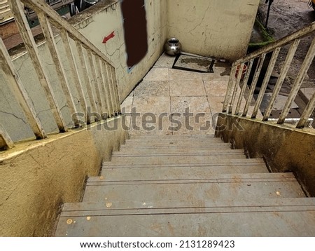 Stock photo of empty and dirty stairs outside of the commercial shop, white color painted grill on the both side of the stairs. Picture captured during day time at Kolhapur, Maharashtra, India.