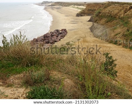 The North coast of Norfolk near Snettisham showing path leading down to a beach with various places on the cliff subject to coastal erosion. Royalty-Free Stock Photo #2131302073