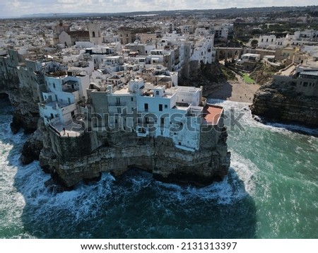 Aerial view of Polignano a Mare, a village built on the edge of the sandstone cliffs above the Adriatic Sea in Apulia, Italy. Drone photography of Lama Monachile bay.