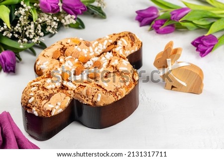 Easter tradition in Italy, Dove Cake topped with icing and almonds.  Colomba di Pasqua. Easter bunny. Spring flowers. Top view.