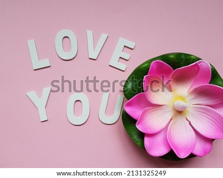word today with arthifical flower and pink background