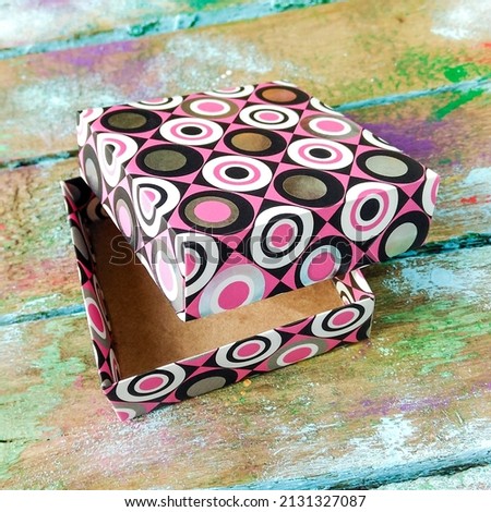 Geometric pink handmade box with open lid. Mobile photo.
