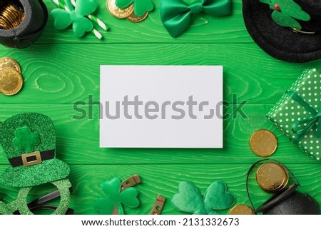 Top view photo of st patricks day decor paper sheet party glasses leprechaun hat straws bow-tie giftbox horseshoe shamrocks pots gold coins on isolated green wooden table background with copyspace