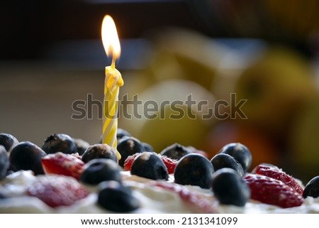 Candle on the birthday cake close-up.
