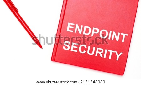 The text ENDPOINT SECURITY is written on a red notepad near a red pen on a white table in the office. Business concept