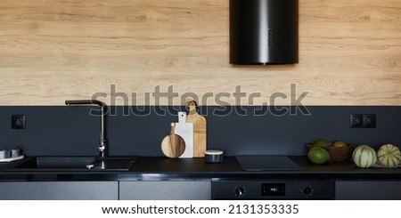 Stylish composition of modern small kitchen interior. Black kitchen workspace with  kitchen accessories. Minimalistic masculine concept. Template.