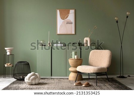 Stylish living room interior design with mock up poster frame, frotte armchair, wooden commode, side table, plants and creative home accessories. Sage green wall. Home staging. Template. Copy space. Royalty-Free Stock Photo #2131353425