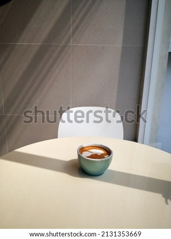 Decorate a coffee cup, take a blurry coffee cup, put it on a table with sunlight.  shine through glass  There is some light and blur in some parts of the picture.