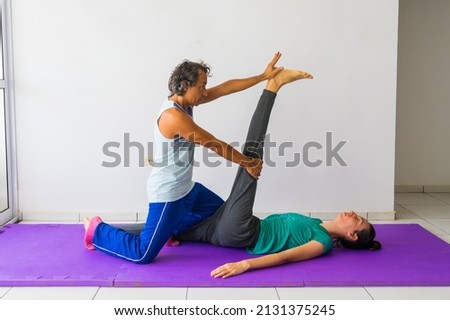 Traditional Thai Massage stretch for the hamstring muscles (thigh and leg). Male massage therapist, female client. Royalty-Free Stock Photo #2131375245