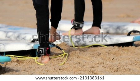 People surfing on the beach in summer, board leash