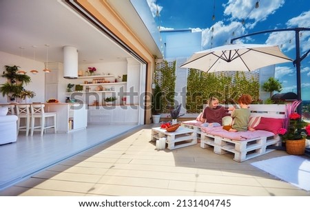 happy kids playing on rooftop patio with open space kitchen and sliding doors
