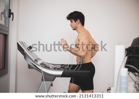 A young athlete undergoes a stress test on a treadmill.It measures the activity of the heart with an electrocardiogram. Royalty-Free Stock Photo #2131413311