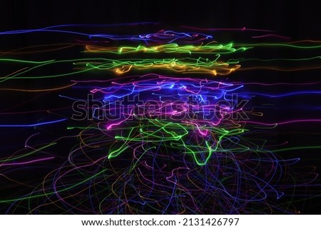 A long exposure photo, the concentration of lines of light is in the middle of the image, blue, yellow, green, purple and pink lines, it looks like something technological, a vortex.