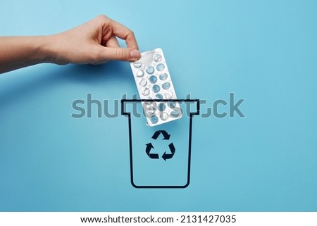 A man throws a package of pills into the trash. A symbol of the non-necessity of the medicine Royalty-Free Stock Photo #2131427035