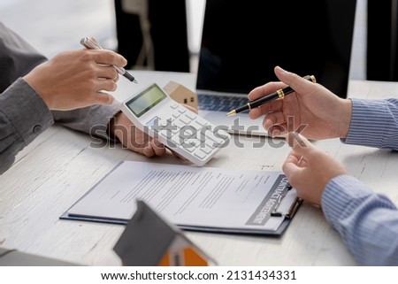 A rental company employee is calculating the cost for the customer to agree to sign a rental contract, explaining the rental terms and conditions. Home and real estate rental ideas.