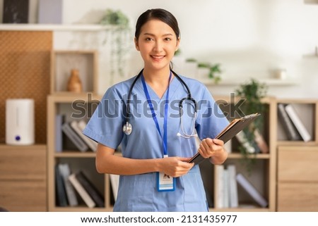 Asian female doctor with a stethoscope smile looking at camera.Nurses wear scrub smile with heartwarming comfortable.Positive emotional and good moment.Health Care Concept Royalty-Free Stock Photo #2131435977