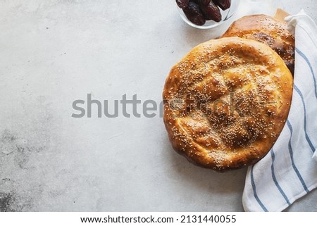 Ramadan Pide - Turkish popular bread for Ramadan month on a gray background. Copy space and top view. Royalty-Free Stock Photo #2131440055
