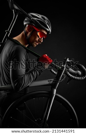 male cyclist with road bicycle on black background Royalty-Free Stock Photo #2131441591