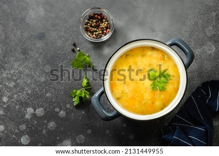 Creamy vegan split pea soup in pot on dark background. Copy space.