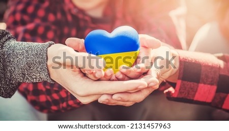 Family hands holding a heart in ucrainian colours. Peace and no war concept Royalty-Free Stock Photo #2131457963