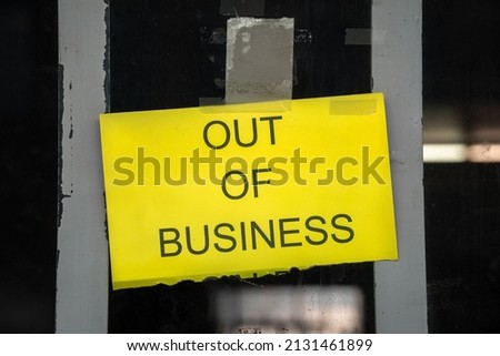 Yellow sign in business window during time of Covid reading "Out  of Business" in a struggling economy, showing the plight of small businesses in the post-pandemic economy.