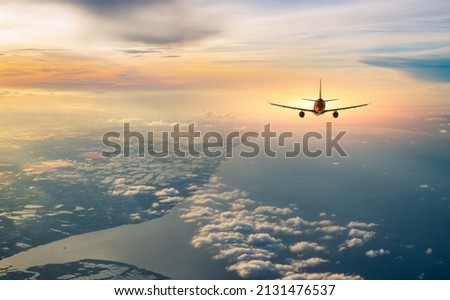 Airplane flying over tropical sea atduring sunset,copy space for text.