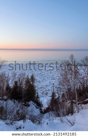 A Portrait Oriented High Angle Landscape Overlooking Pancake Ice Formations on Lake Superior During a Winter Sunset