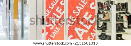 Sale sign at the entrance to clothing store,large red panels with white words. Seasonal discount offer in store. Discounts and black friday concept.Fashion concept,offline shopping, holiday sales.
