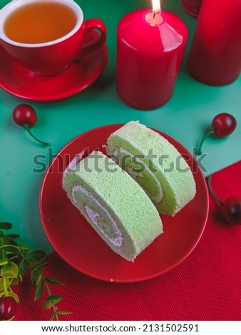 top view of pandan roll cake with green and red background