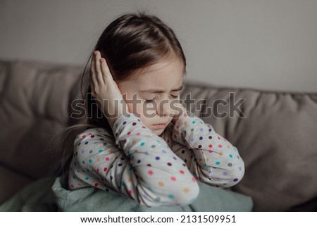 Stop war. Pray for Ukraine. we stand with Ukraine. Ukrainian frightened child under a blanket. The girl is afraid of the sounds of air raids and explosions. Poor child feeling sorrow and sadness. Royalty-Free Stock Photo #2131509951