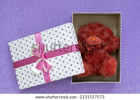 View from above. The gift box is open. The lid of the box is next to it. Gift in an elegant beautiful box. soft toy bear. cute and romantic picture
