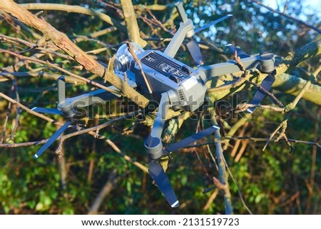 Broken destroyed drone after an accident hanging in the branches of a tree. Selective focus