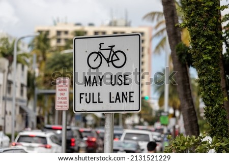 A traffic sign indicating bikes may use full lane with a picture of a bike in Miami Beach Florida.