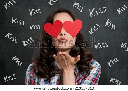 Young Woman Blowing Kiss With Heart Shape Paper Sticker Covered On Eyes On Blackboard