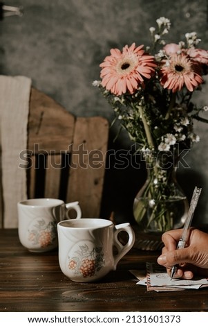 still life of flowers and mug on wooden table. darkmood