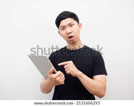 Man point finger at tablet in hand feeling serious white background